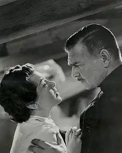 Woman facing a man, holding her shoulders