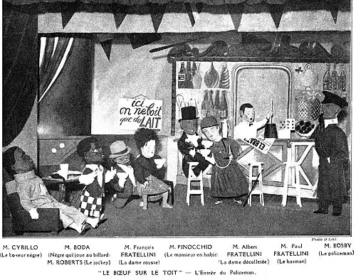 stage scene in a bar with characters wearing large cardboard heads