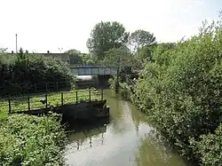 View of Sheepwash Channel, with the site of the old swing bridge in the foreground and the newer railway bridge in the background.