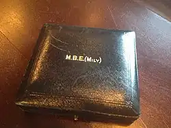 Square, blue leather case with gold lettering. MBE bracket Mily bracket