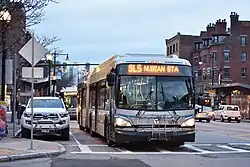 Two silver-painted buses on an urban street