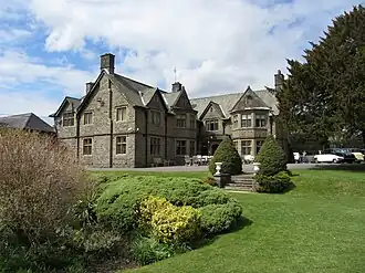 a large stone building with shrubs and grass in the foreground