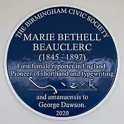 Circular blue plaque with white text reading "The Birmingham Civic Society. Marie Bethell Beauclerc (1845–1897) First female reporter in England. Pioneer of shorthand and typewriting and amanuensis to George Dawson. 2020" Also includes a sample of shorthand.
