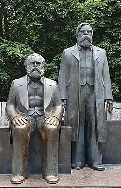 Photo of a statue of two men, one sitting and the other standing