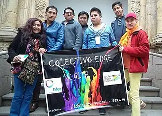 Carlos Parra and other organizers hold up a banner advertising the name of their collective, "Colectivo Edge".