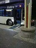 A hybrid bus with its accessibility ramp extended