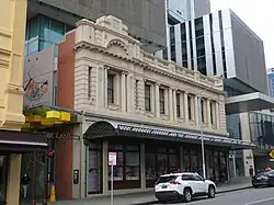 The same building as before, fully restored and with a modern development behind