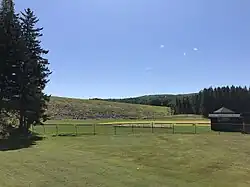 View of Murphy Dam looking up at the embankment; fence in the foreground is part of a local baseball field