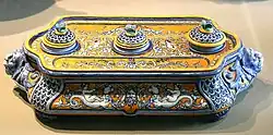 Photo of a Gien faience inkwell with blue patterns on an ivory and yellow background