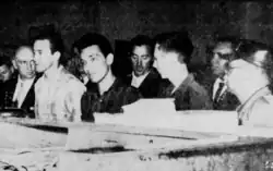 Black and white photos of the members of the NRP sitting. Burros is to the right wearing a cap
