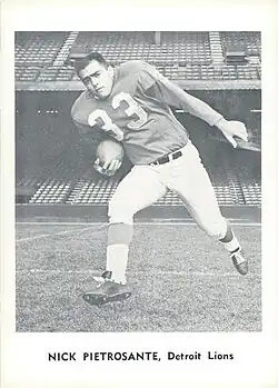 Nick Pietrosante shown in a promotional image wearing a Detroit Lions uniform, without a helmet, and carrying a football.