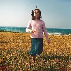 A girl running in a field, smiling