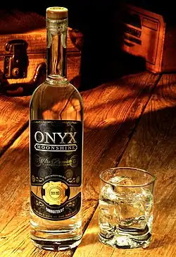 A bottle with a dark label, and a glass