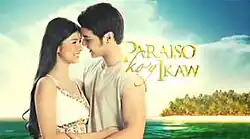 An image of Kim Rodriguez and Kristoffer Martin looking at each other, with the sky, the sea, a beach and trees on the background. The series title is displayed on the center of the image.