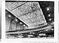 1932 image of auditorium ceiling and balcony soffit. Round holes in balcony edge are for stage lighting instruments. Dark windows in far wall are for film projectors and spotlights.