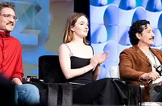 Three people sitting on a stage