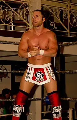 Petey Williams posing in a wrestling ring.