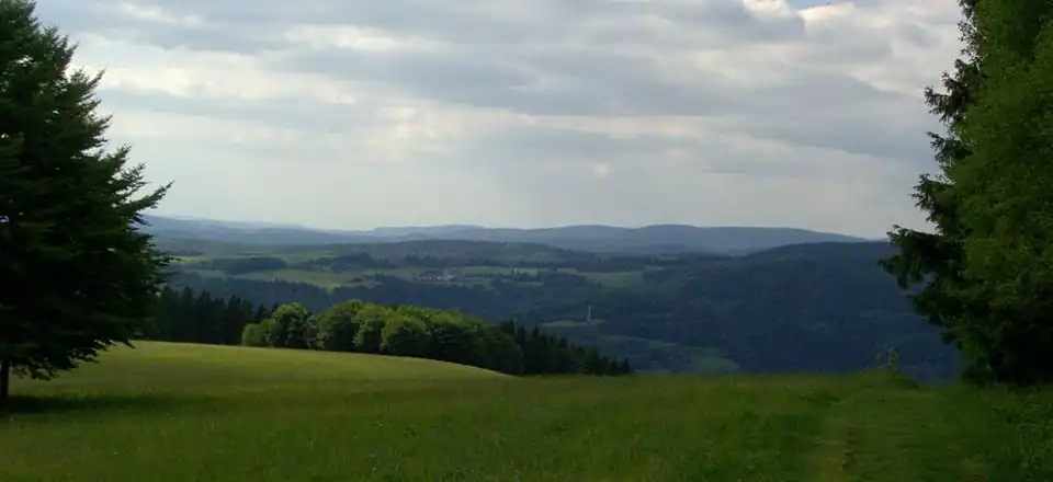 View of the Pleß (645&nbsp;m, left of centre, 52&nbsp;km away) in the northeast of the Vordere Rhön and the 14-km-distant Adlersberg (849,9&nbsp;m) with the Neuhäuser Hügel (891&nbsp;m)