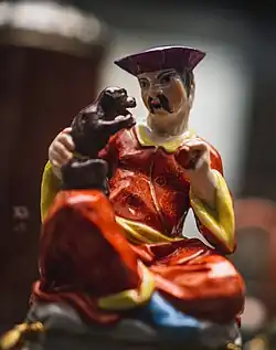 Man seated on plinth, holding monkey and ball. Meissen factory. Dated c. 1735. British Museum