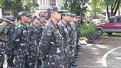 Personnel of the 1st QC TASU await instructions from their officers.