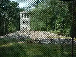 Mound and observation tower viewed through protective fence