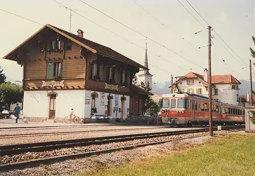 Two-story building next to an orange train