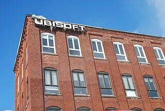 White logo of Ubisoft, covered in icicles, on the facade of the Peck Building