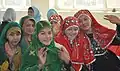 Hazara girls (right) wearing red traditional dress sitting next to Tajik and Pashtun girls in Ghazni, Afghanistan