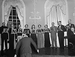 Singers holding individual signs with a single letter that collectively spell "Inner Wheel"