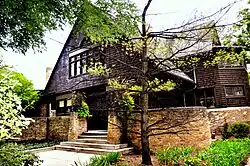 The house entrance on Forest Avenue. A short set of stairs leads up to the house, and there is a low brick wall on either side of the stairs.
