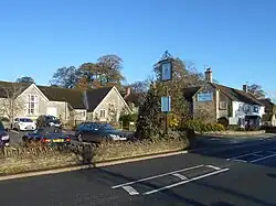 Building with pub sign saying the Sparkford Inn with car park and road in the foreground.