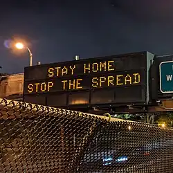 Variable-message sign reading "STAY HOME, STOP THE SPREAD"