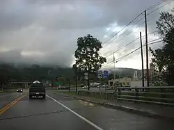 A cloudy sky hanging over a 2 lane road