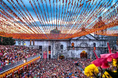 Large crowd outside a colorfully-decorated church
