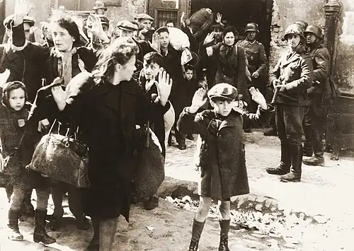 Image 11 Warsaw Ghetto Uprising Photo credit: USHMM Jews captured by SS and SD troops during the suppression of the Warsaw Ghetto Uprising are forced to leave their shelter and march to the Umschlagplatz for deportation. The SD trooper pictured second from the right, is Josef Blösche, who was identified by Polish authorities using this photograph. Blösche was tried for war crimes in Erfurt, East Germany in 1969, sentenced to death and executed in July of that year. More featured pictures