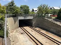 A railway tunnel portal surrounded by a brick retaining wall