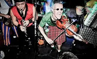 Terra Celta live at Casa Fora do Eixo in Uberlândia in 2010. Edgar Nakandakari (no longer in the band) is to the left and Elcio Oliveira is to the right. Behind them is Luiz Fernando Sardo. Partially cut out of the picture are Bruno Guimarães (far right) and Alexandre Garcia (far left). Eduardo Brancalion is not shown.