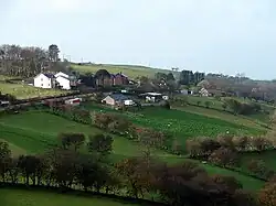Green landscape with a few home and lined with trees