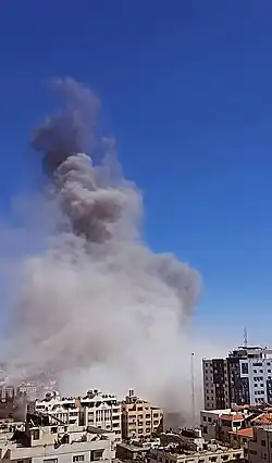 Smoke rising from the collapsed building after the Israeli strike, 15 May 2021