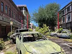 Film set of broken cars with growing foliage