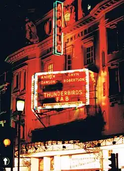 A neon sign for a stage play at the Apollo Theatre reads "Andrew Dawson – Gavin Robertson – Thunderbirds FAB – A Forbidden Planet Production"