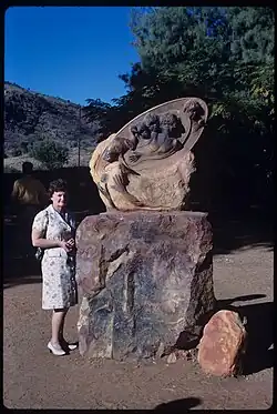 A tourist standing with one of the sculptures in 1969