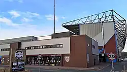 A brick-walled building which contains the club shop. It is located between two large stands.