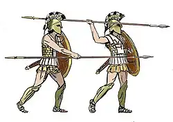 A color illustration of the overhand (right) and underhand (left) attack positions of the hoplites, who are shown wearing their panoply armor and plumed helmets.
