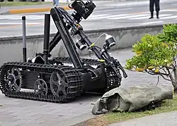 US Navy 090512-N-2013O-013 A Mark II Talon robot from Explosive Ordnance Disposal Mobile Unit 5, Det. Japan, is used to inspect a suspicious package during a force protection-anti-terrorism training exercise.