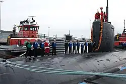 Santa Claus stands with sailors aboard Miami during the submarine's return to Naval Submarine Base New London after an eight-month deployment. (2 December 2009)