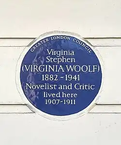 A photograph of the Virginia Woolf blue plaque at Fitzroy Square. It reads 'Virginia Woolf 1882-1941 Novelist and Critic lived here 1907–1911.'