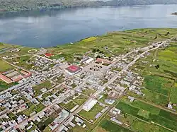 The train the Belmond Andean Explorer[1] at La Raya Station with market stalls and the mountain Chimpulla in the background, Layo District-Santa Rosa District