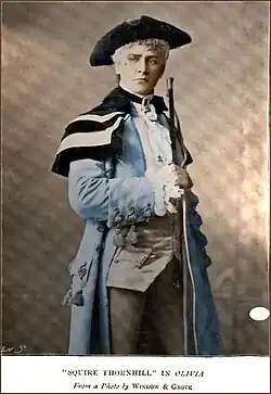 Terriss, in 18th-century costume, holding a rifle