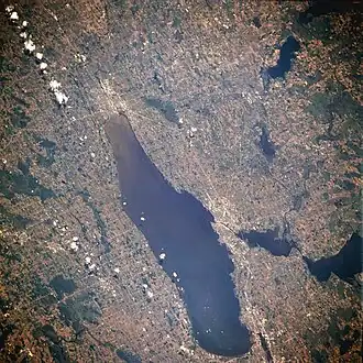 From space (July 1996). The string of clouds in the upper left of the image runs almost perfectly north–south, with north being at the bottom of the image.